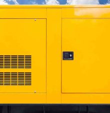 Big yellow mobile diesel box of autonomous generator for emergency electric power stand outside with blue cloud sky
