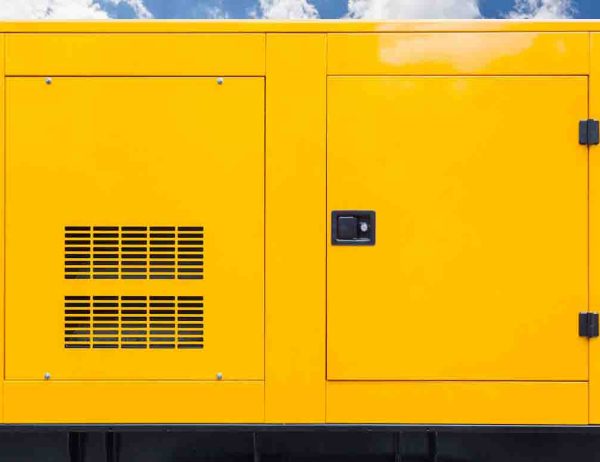 Big yellow mobile diesel box of autonomous generator for emergency electric power stand outside with blue cloud sky